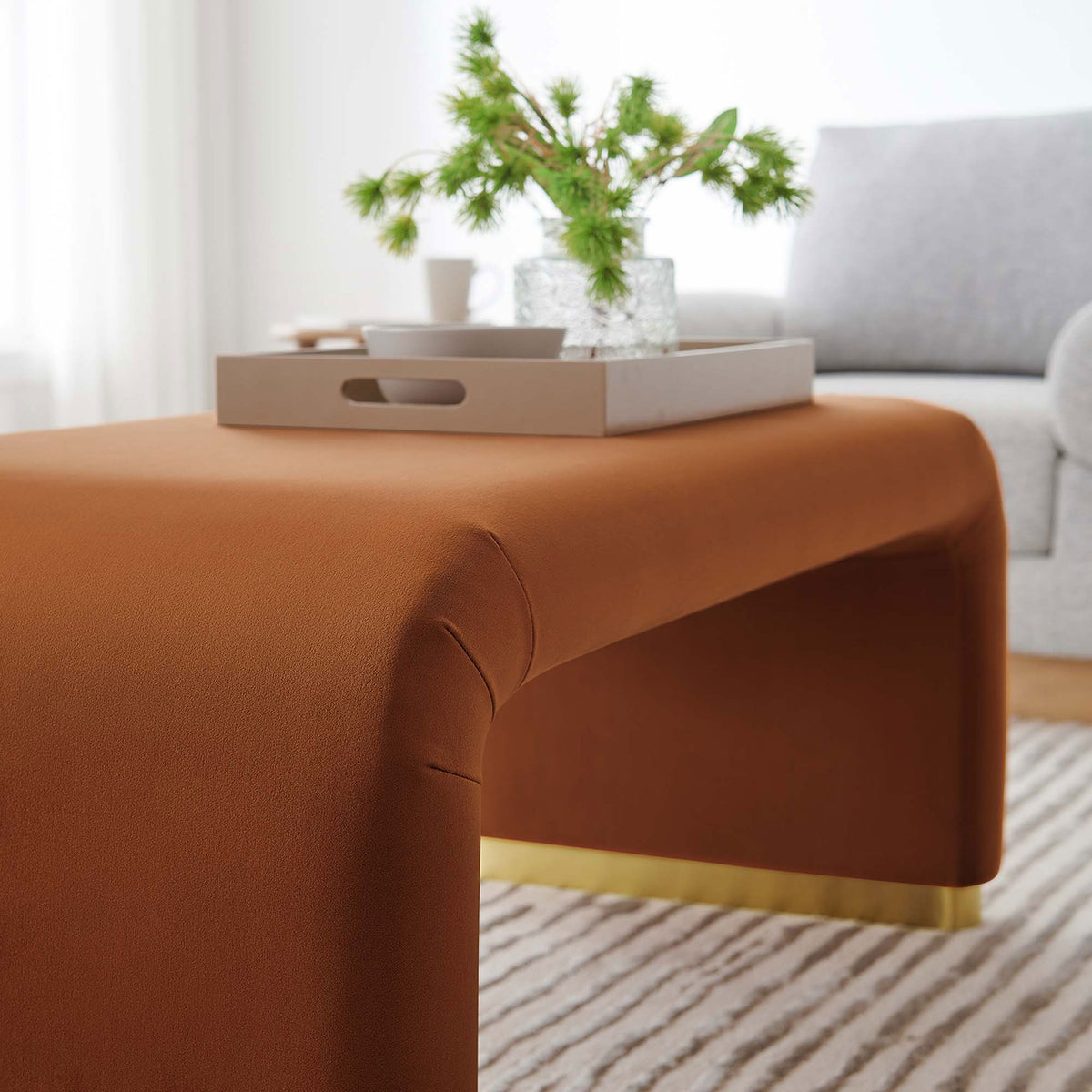 Brass rust waterfall ottoman styled with a tray and decor in a cozy light-filled living room || EEI-6735-BRA-RUS || detail_room