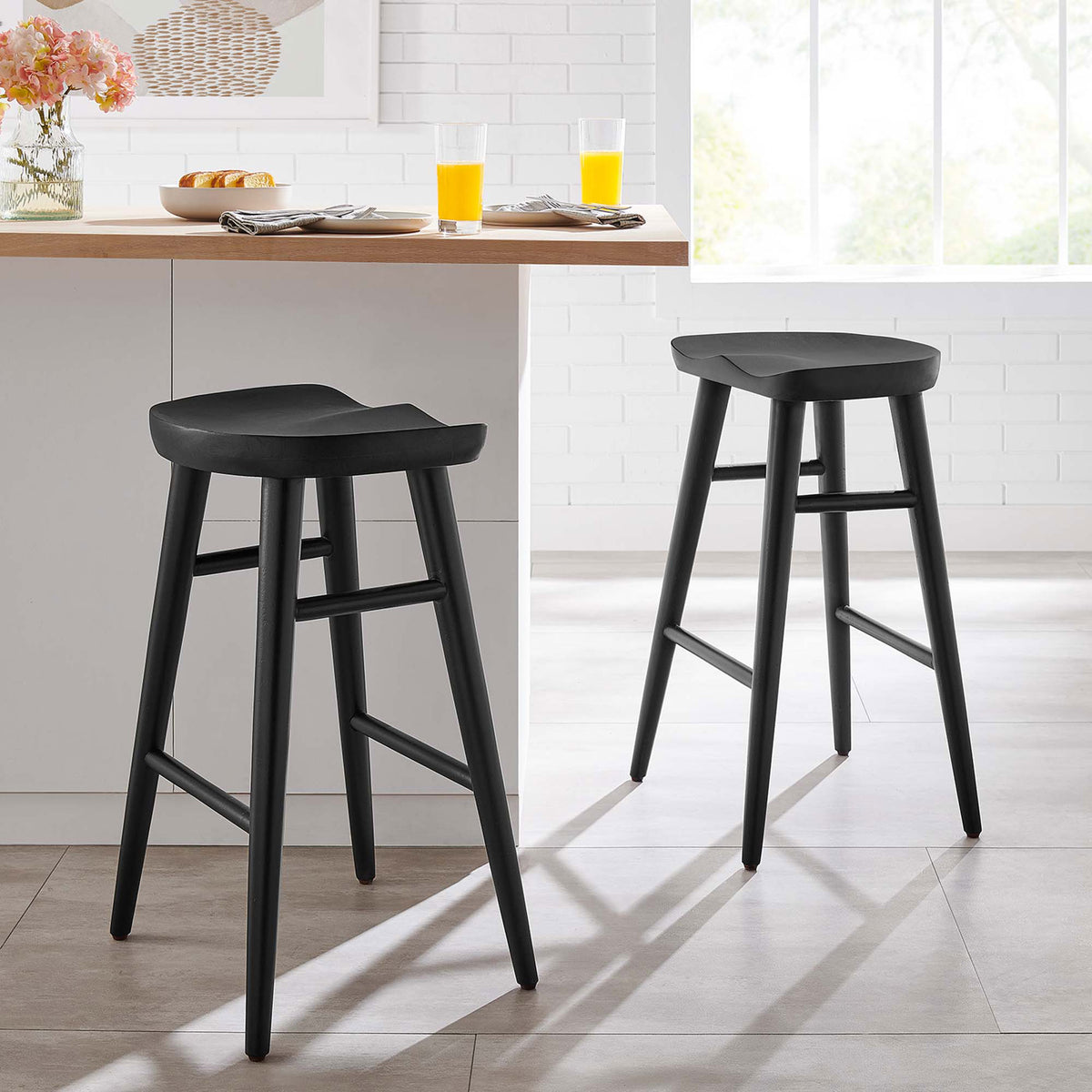 Two counter stools elevate a bright kitchen with sculpted seats and slim black wood frames. || EEI-6739-BLK || front_angle_multi_room