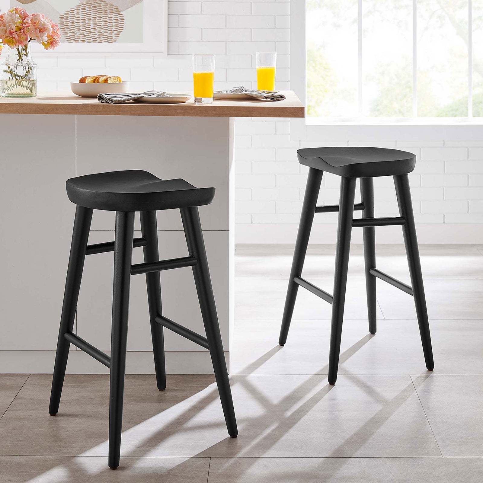 Two counter stools elevate a bright kitchen with sculpted seats and slim black wood frames. || EEI-6739-BLK || front_angle_multi_room