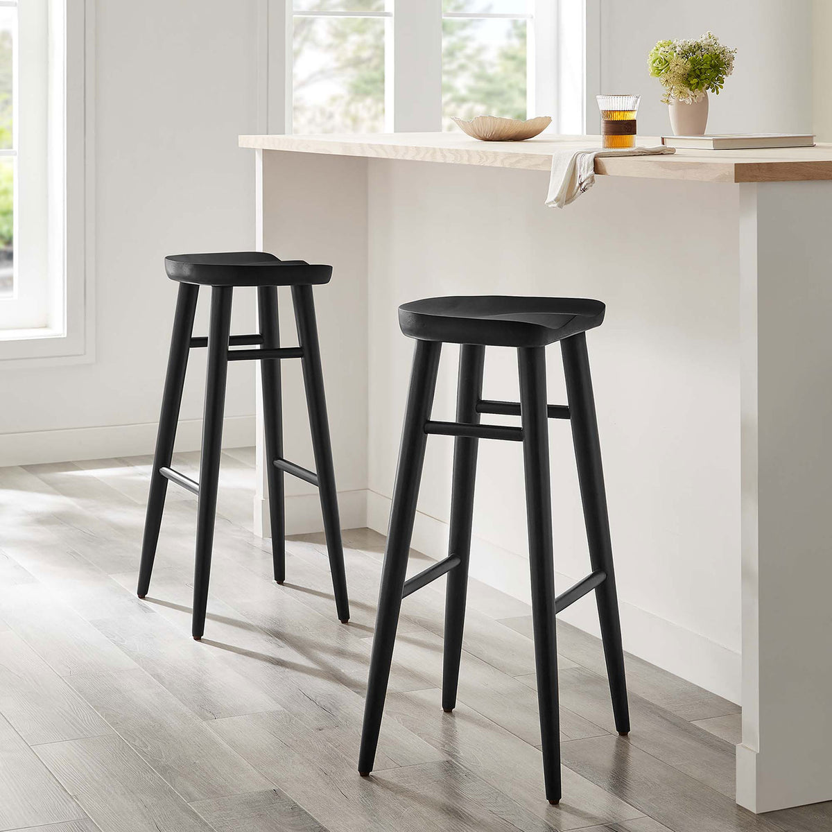 Two bar stools bring refined texture to a bright kitchen with sculpted seats and slim frames. || EEI-6740-BLK || front_angle_multi_room