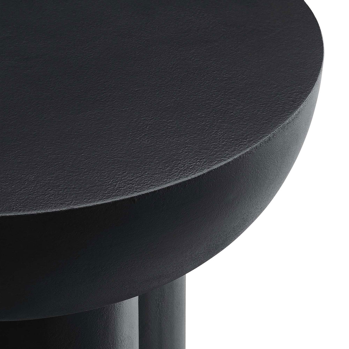 Detail of the thick round tabletop with softly curved edge and concrete overlay in matte black || EEI-6761-BLK || detail_studio