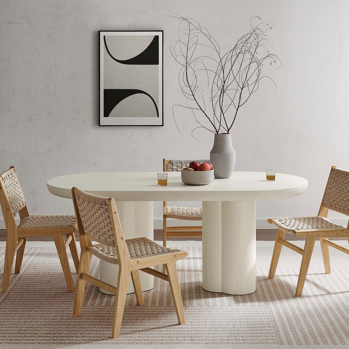 Caspian white oval dining table paired with woven chairs in a warm contemporary dining space || EEI-6764-WHI || front_angle_room
