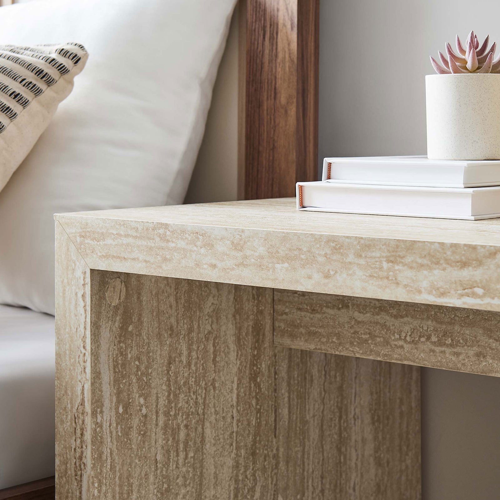 Faux travertine tabletop and apron bring warm texture to a bedside vignette with books, succulents, and wood accents || EEI-6772-TRA || detail_room