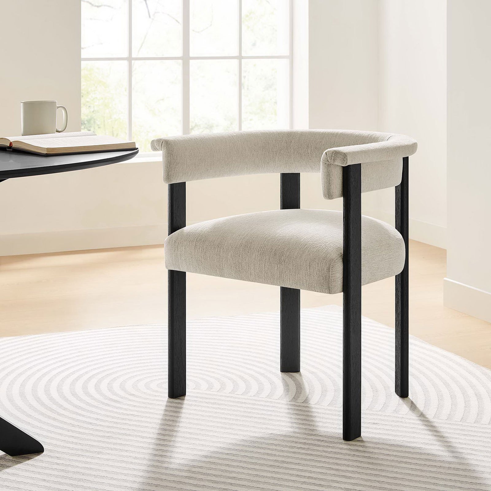 Imogen barrel dining chair styled at a modern dining table on a soft patterned area rug || EEI-6776-HEI-BLK || front_angle_room