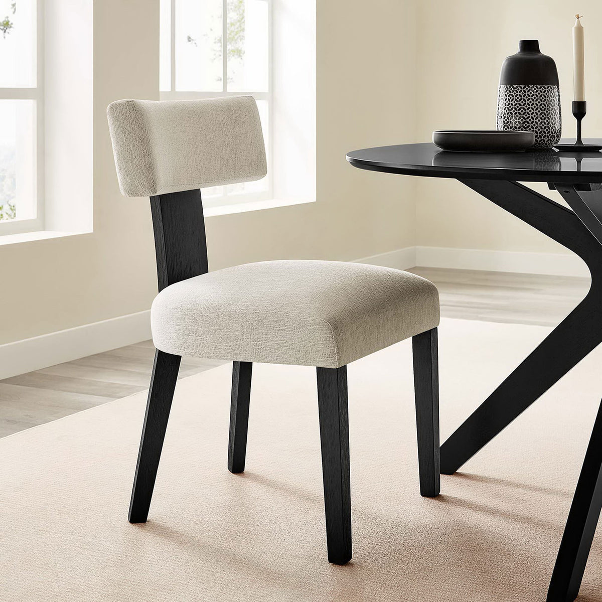 Ivory dining chair with black wood legs styled beside a modern round table in a bright room || EEI-6777-HEI-BLK || front_angle_room