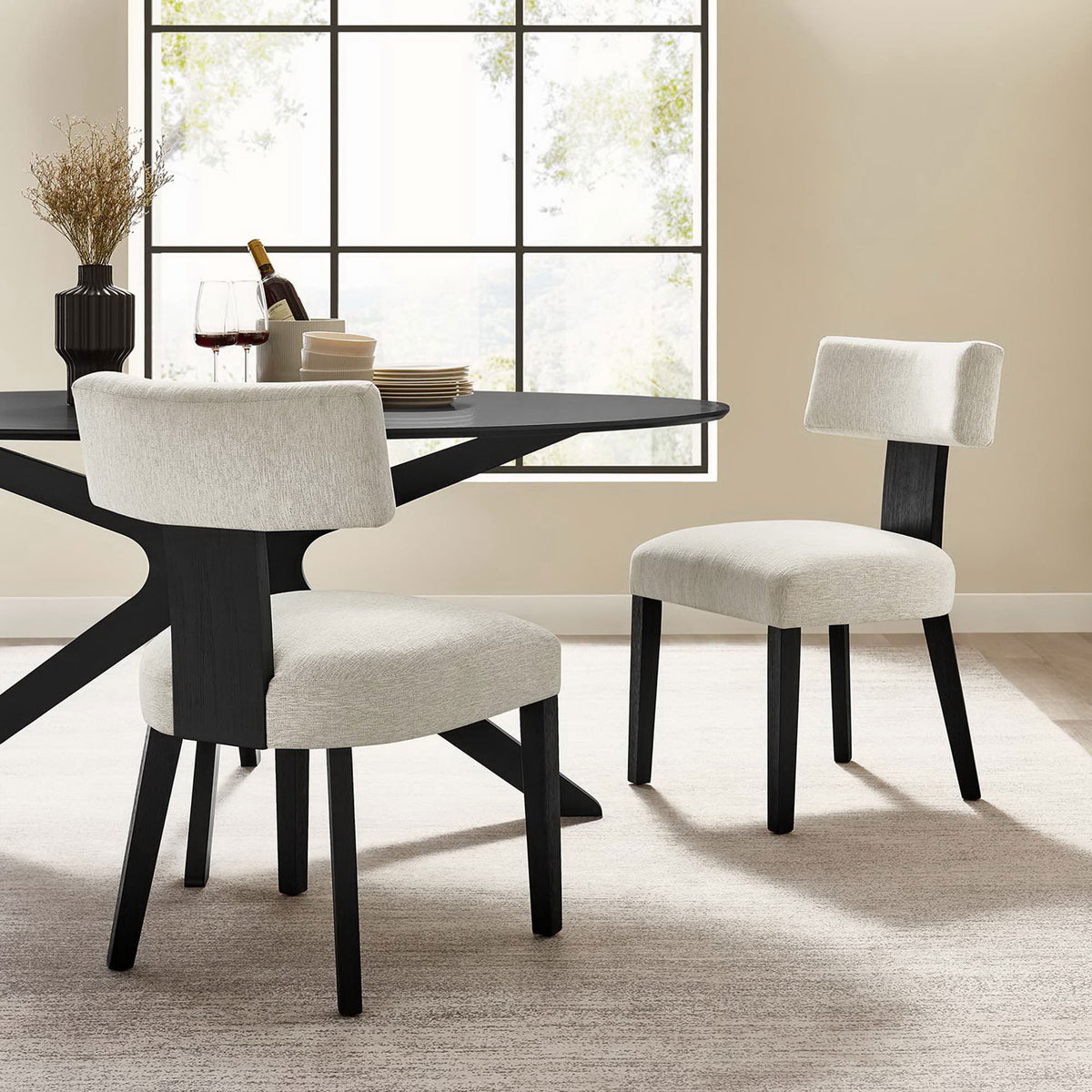 Set of two ivory dining chairs with black wood legs arranged around a contemporary dining table || EEI-6777-HEI-BLK || front_angle_multi_room