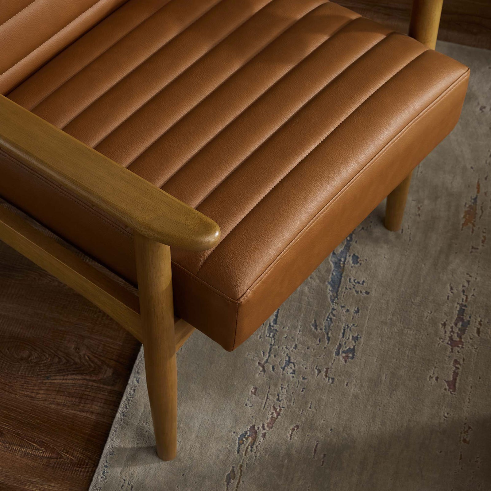 Supple tan vegan leather and smooth wood armrest bring room-ready warmth and texture to your seating area. || EEI-6779-FRO-TAN || detail_room