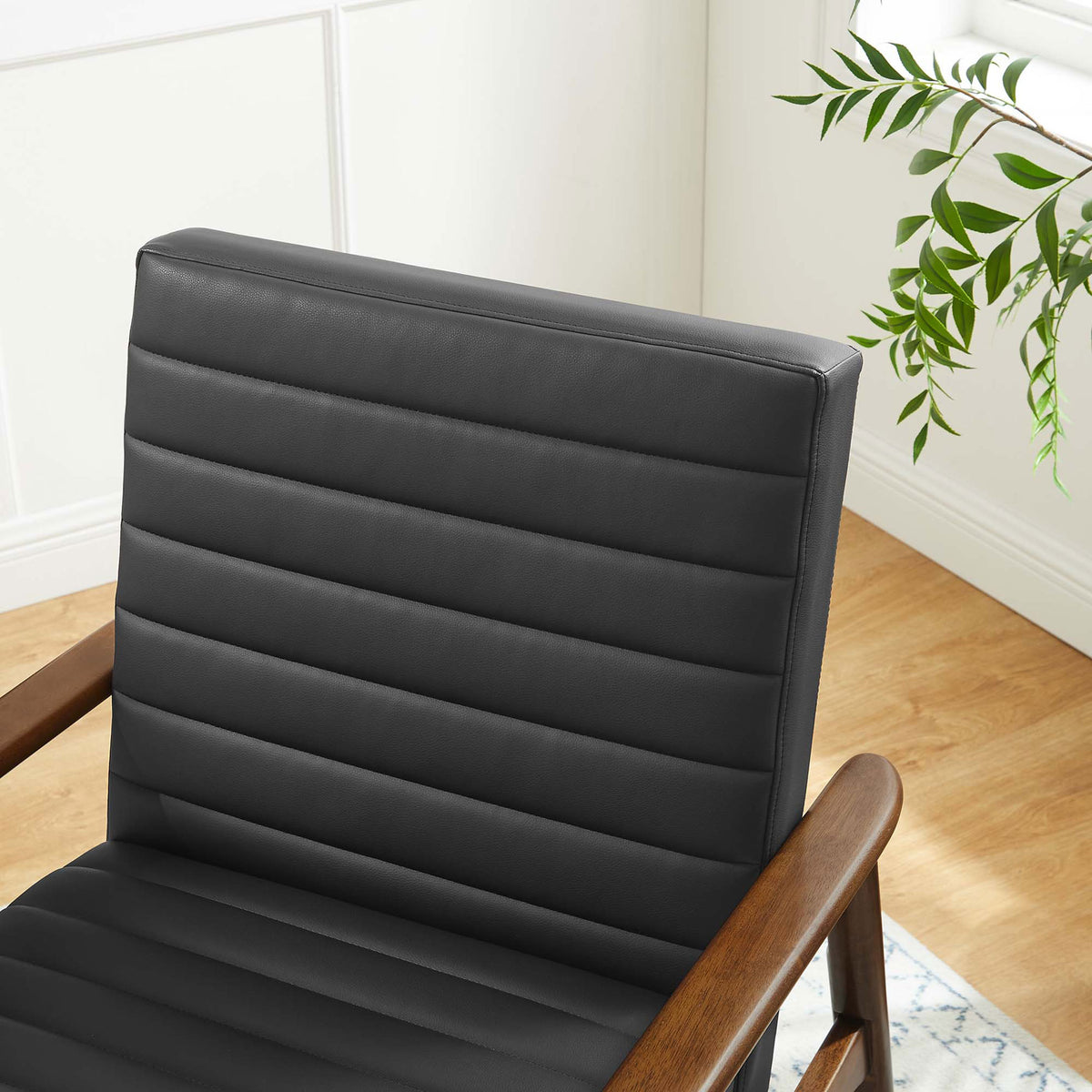 Rich walnut finish and black upholstery add warm contrast in modern spaces. || EEI-6779-WAL-BLK || detail_room