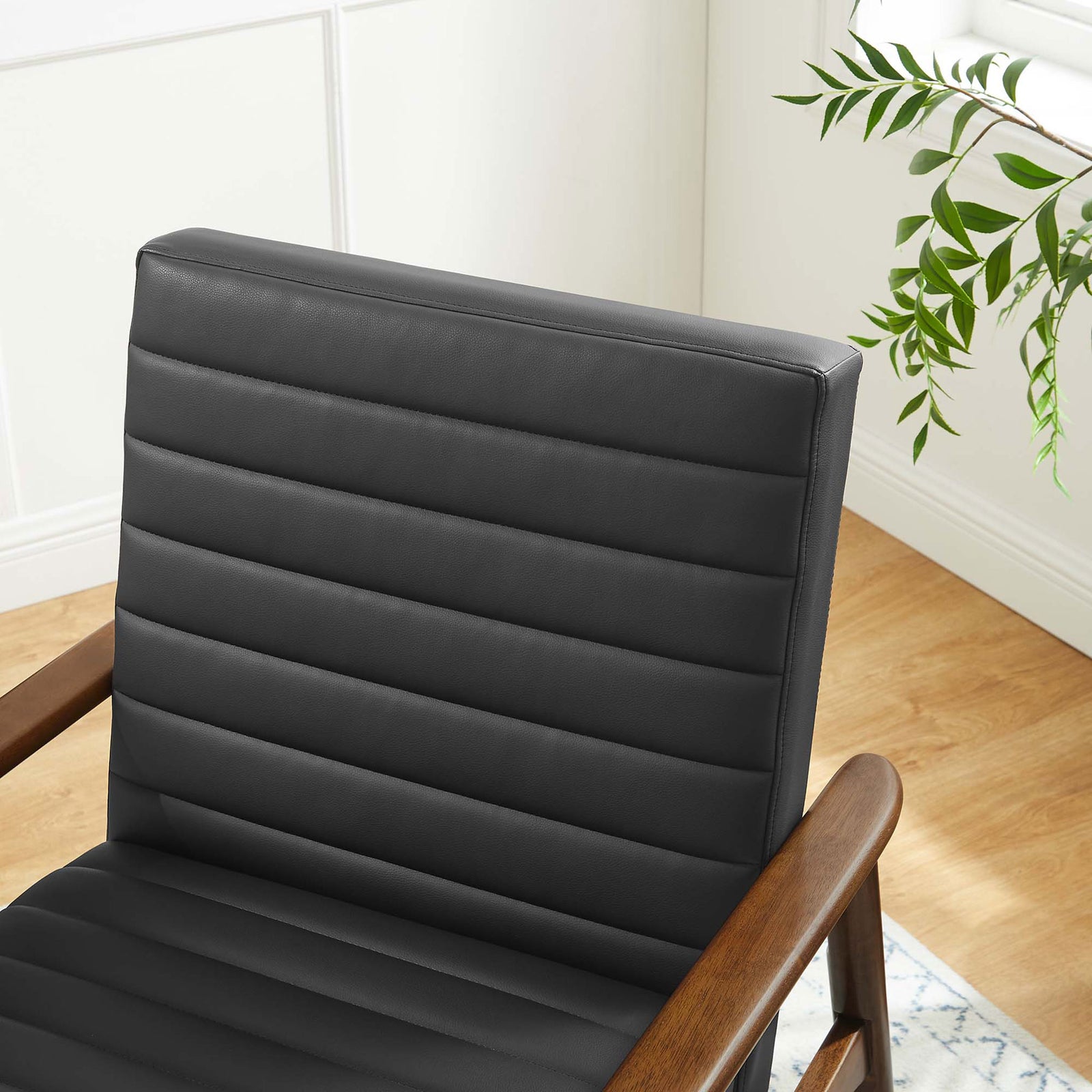 Rich walnut finish and black upholstery add warm contrast in modern spaces. || EEI-6779-WAL-BLK || detail_room