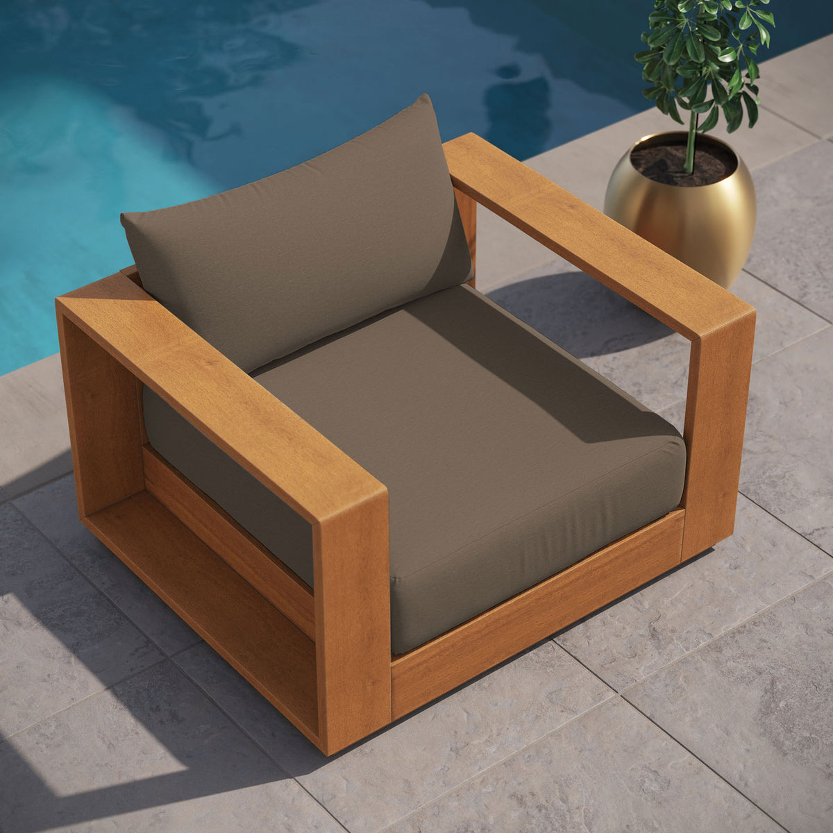 Tahoe outdoor chair with deep cocoa cushions arranged beside a sparkling pool on stone pavers || EEI-6782-NAT-COA || top_angle_room
