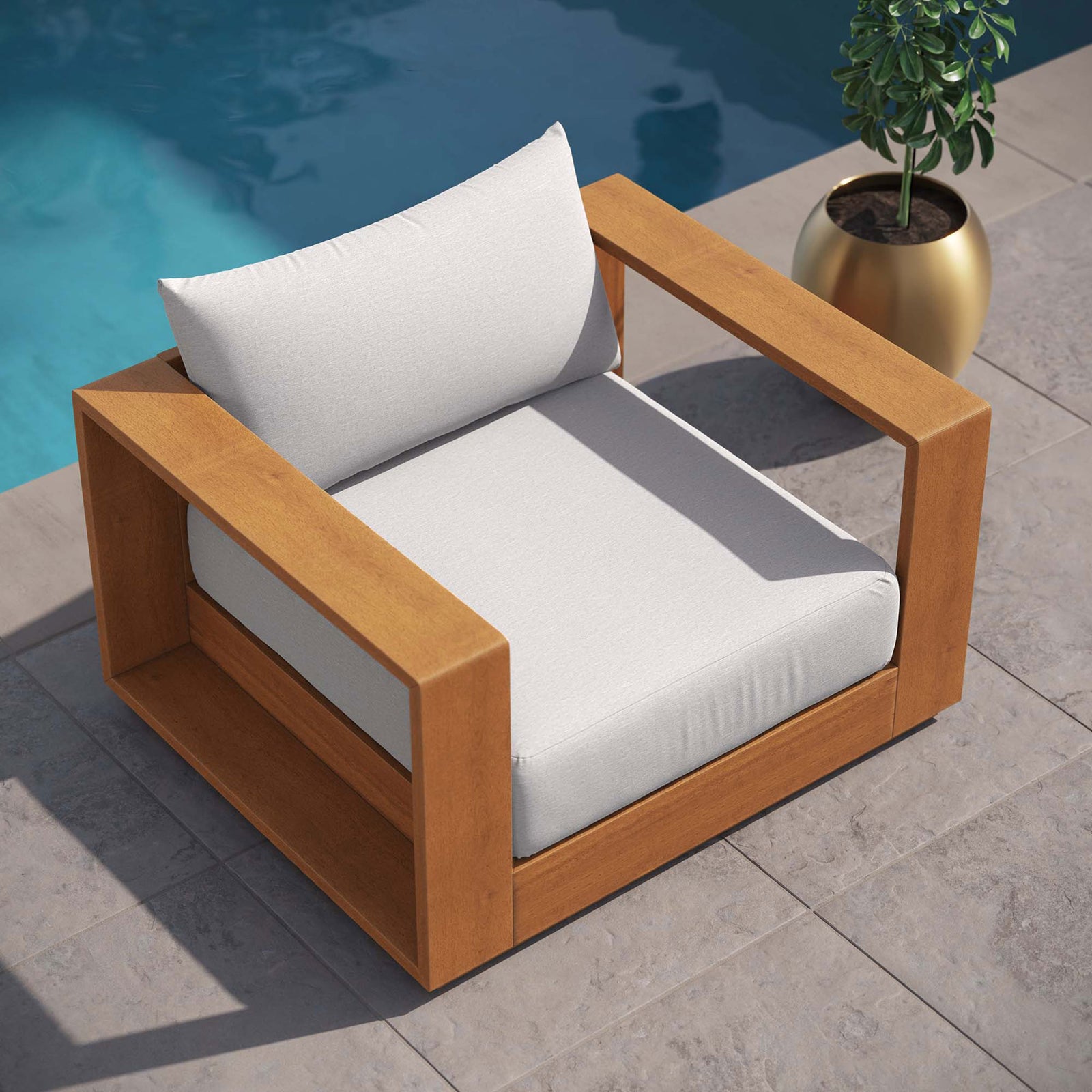 Tahoe outdoor lounge chair with light gray cushions arranged near a blue pool on stone pavers || EEI-6782-NAT-LGR || top_angle_room