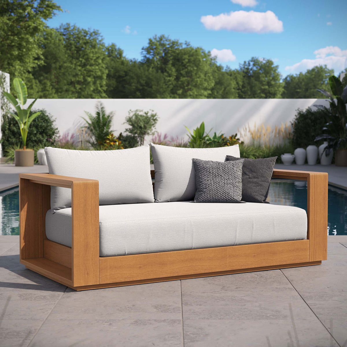 Tahoe acacia wood outdoor loveseat with light gray cushions styled on a poolside patio with accent pillows || EEI-6783-NAT-LGR || front_angle_room