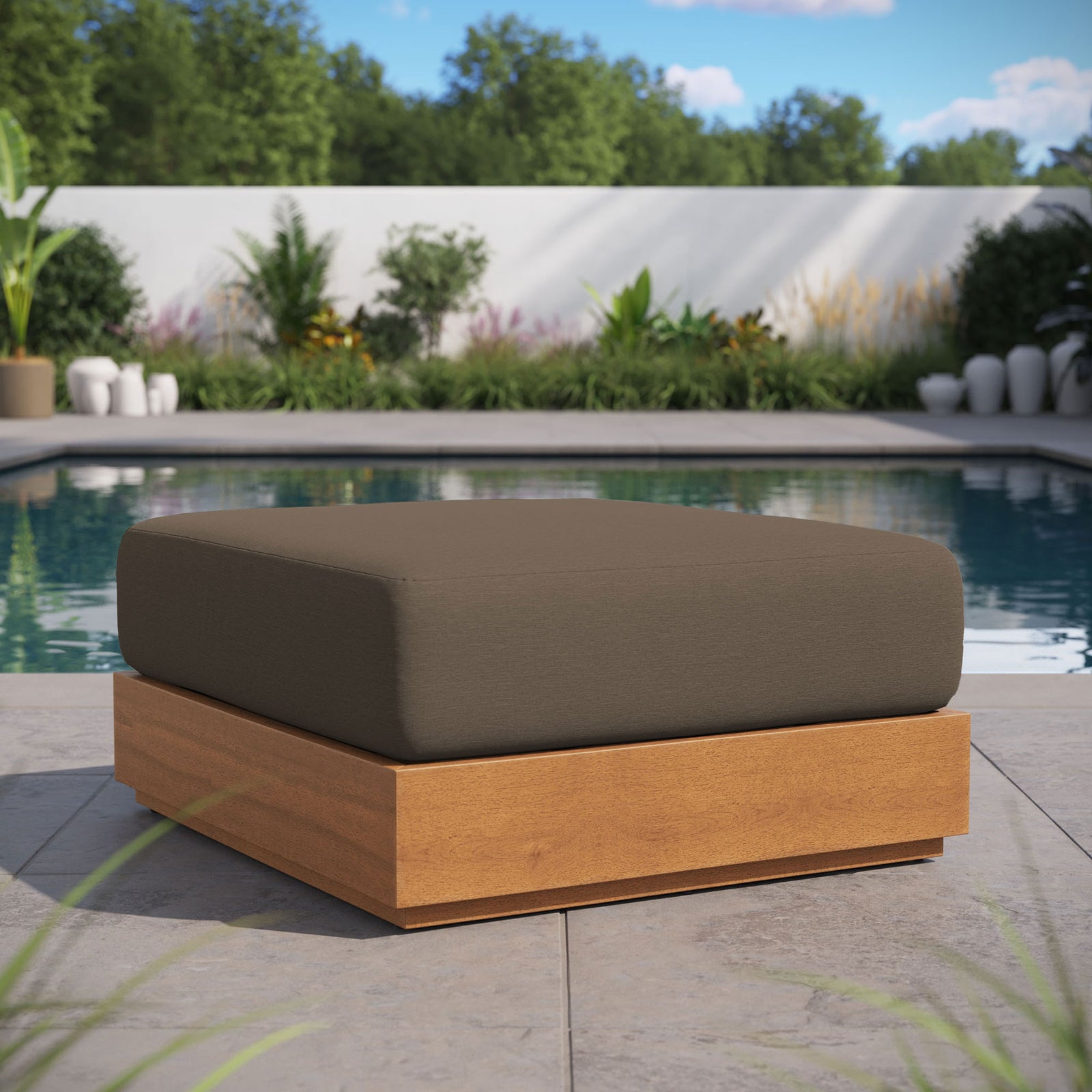 Outdoor Tahoe ottoman creates a cozy footrest on a modern tile patio with lush greenery backdrop || EEI-6785-NAT-COA || front_angle_room