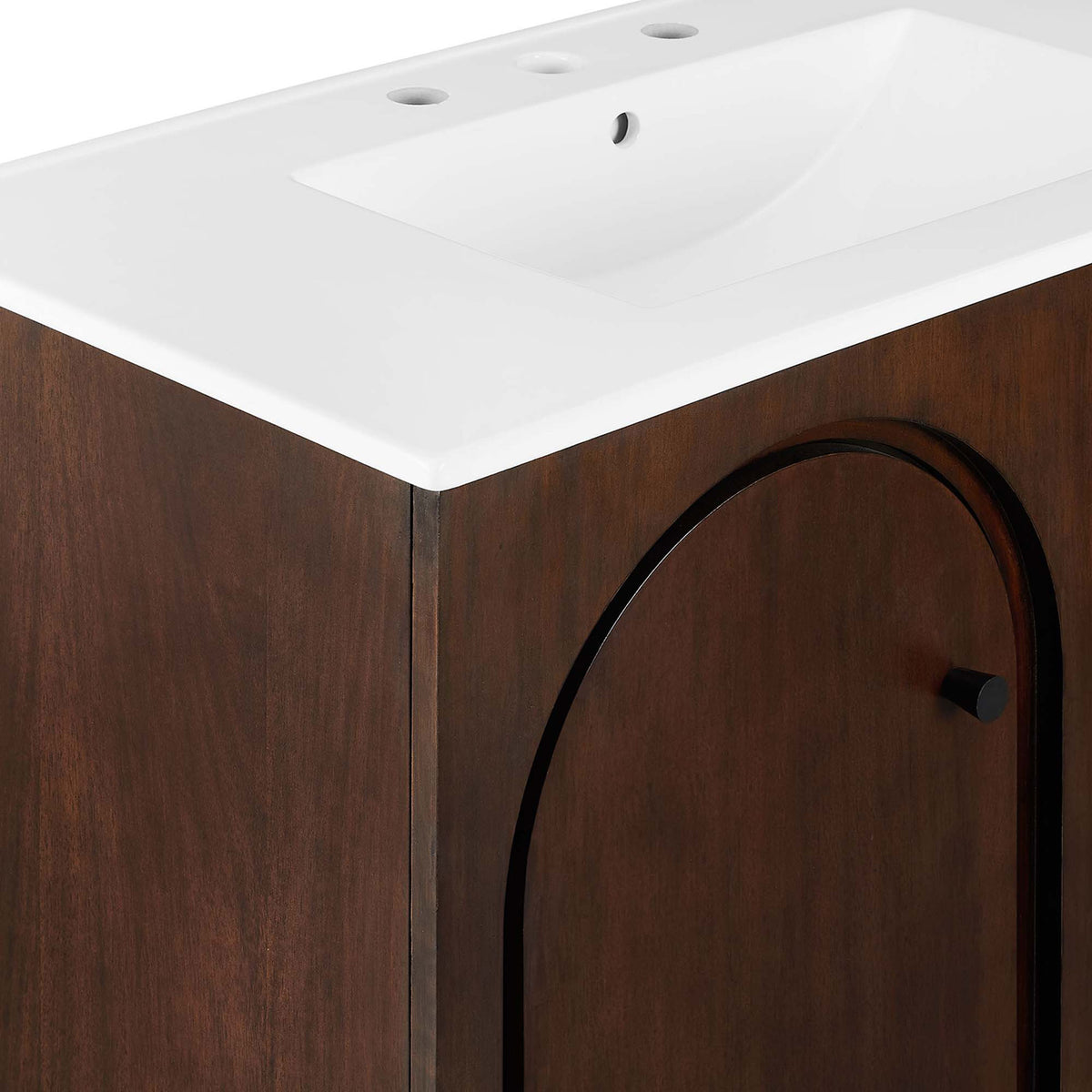 Crisp counter edge and smooth basin meet a warm walnut facade with subtle arched trim and black knobs || EEI-6790-WAL-WHI || detail_studio