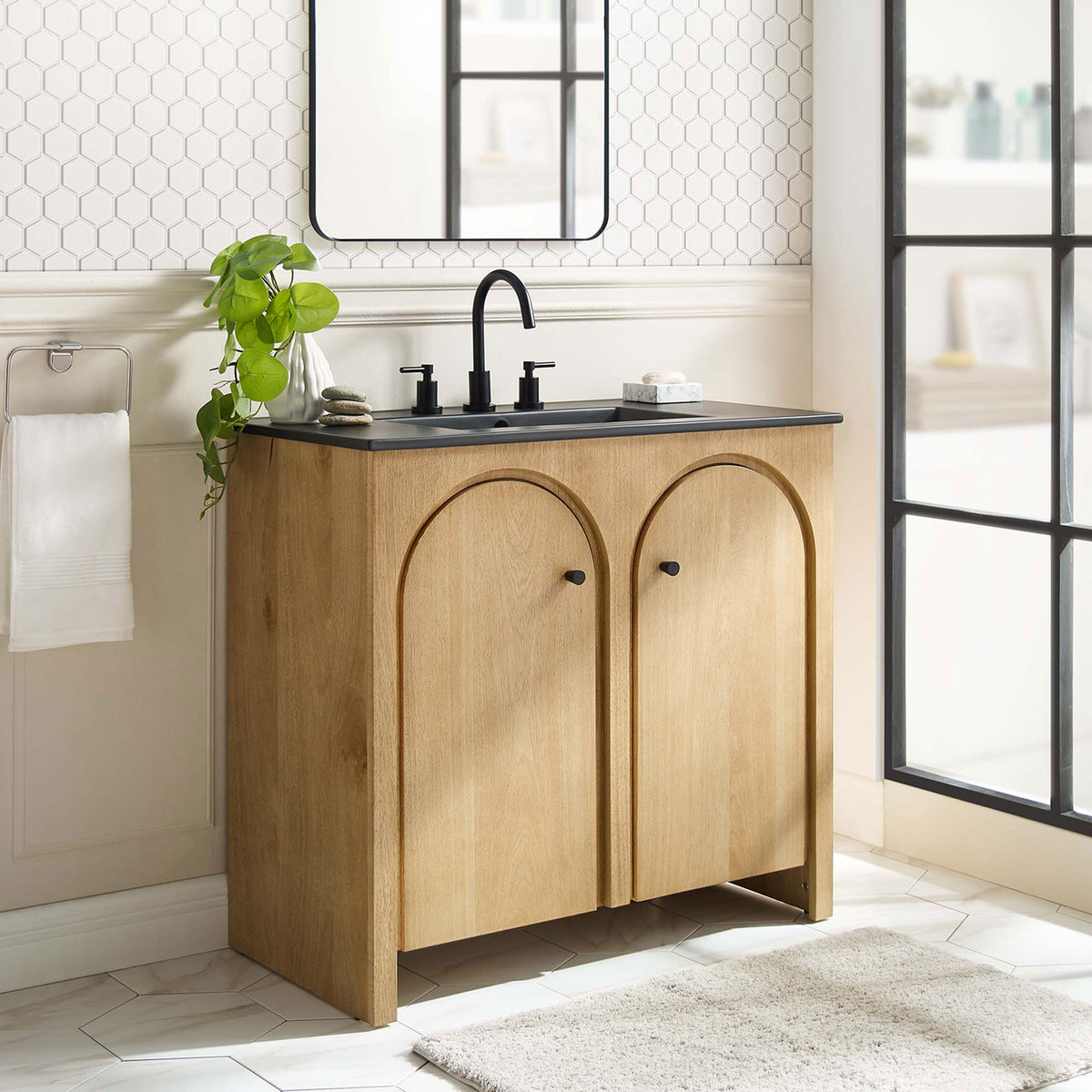 Modern oak vanity elevates the bath with graceful arches and a striking black basin. || EEI-6791-OAK-BLK || front_angle_room