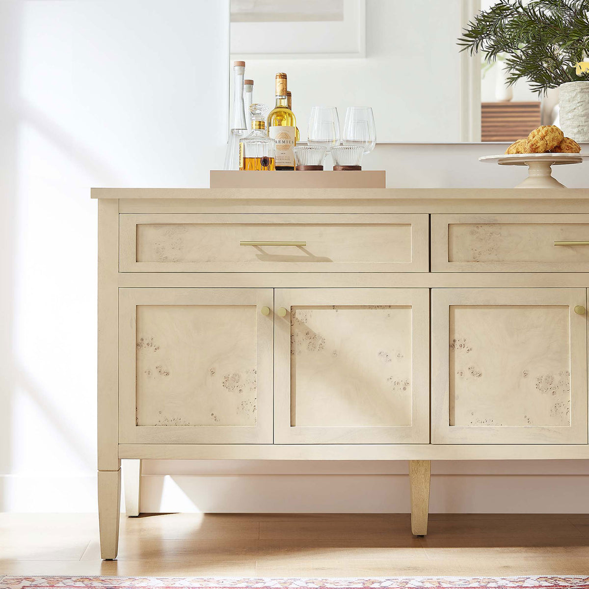 Bleached burl wood sideboard styled as a chic home bar with tray, glassware, and brass accents in a bright room || EEI-6794-BUR || detail_room