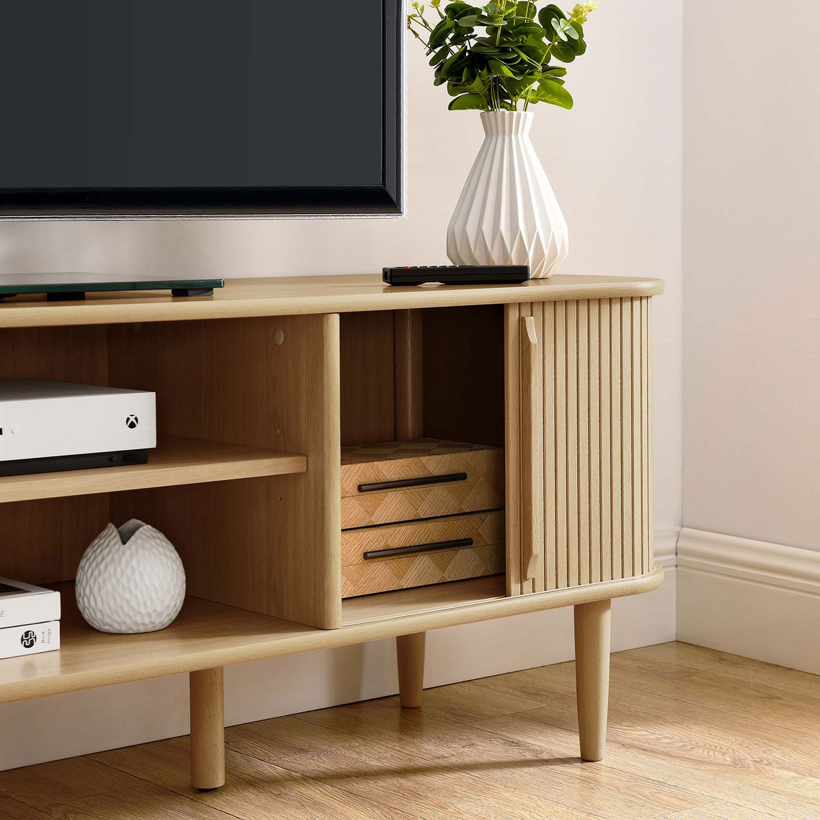 Sliding beadboard doors move smoothly across the front of the oak TV stand || EEI-6795-OAK || storage_open_studio