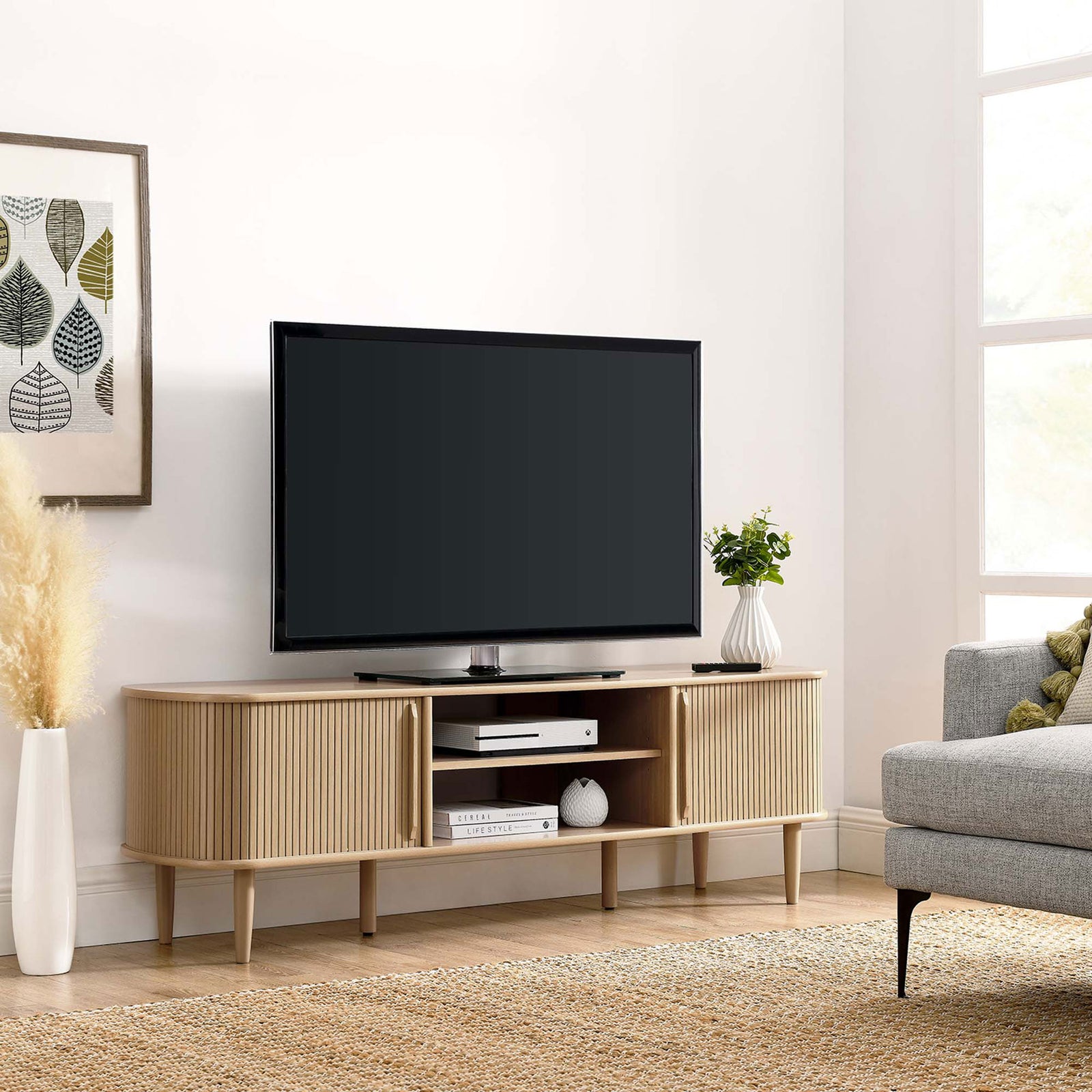 Oak TV stand in a styled room with sliding door revealing neatly stored items || EEI-6795-OAK || front_angle_room