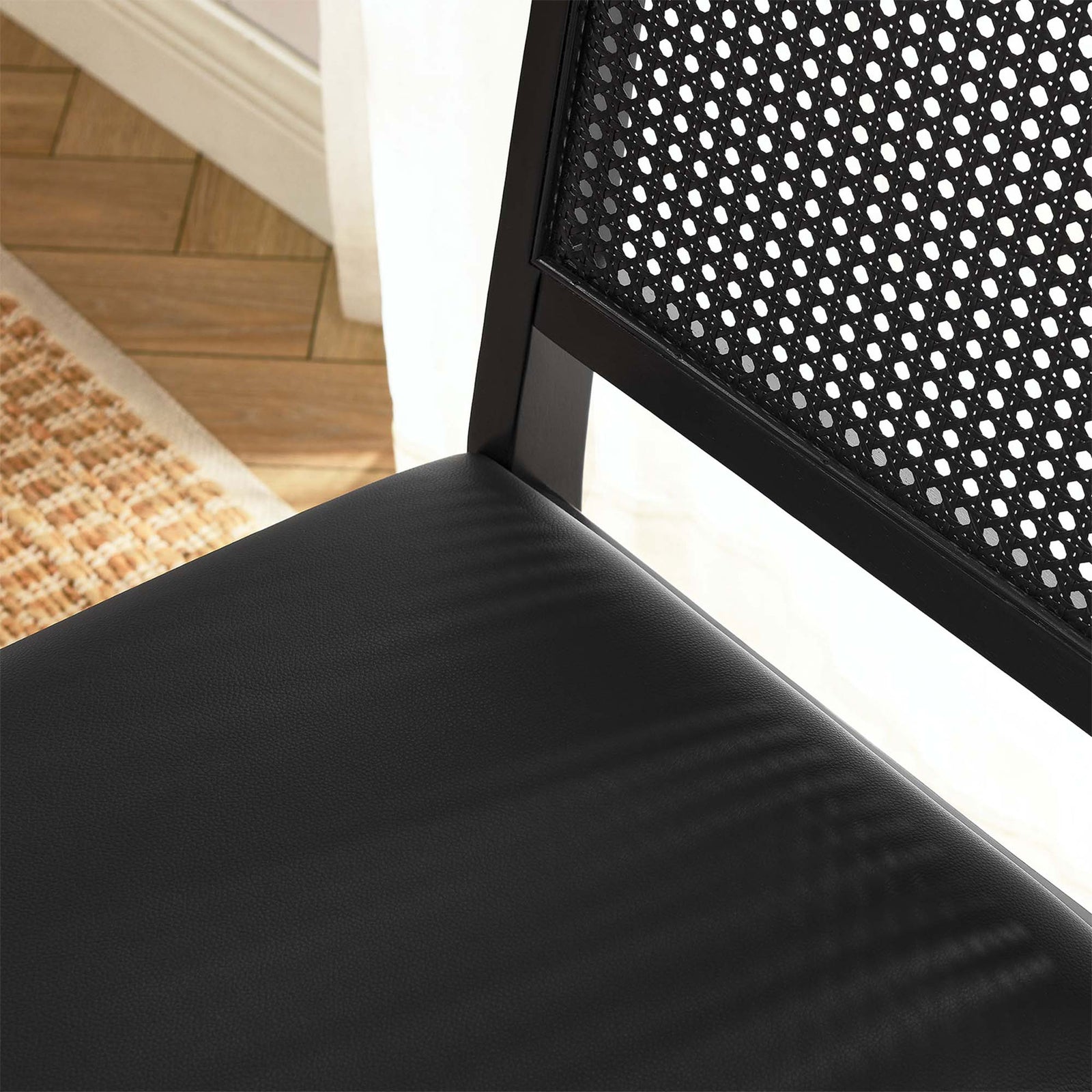 Black vegan leather seat and cane backrest bringing modern contrast to a warm dining room setting || EEI-6802-BLK-BLK-BLK || detail_room