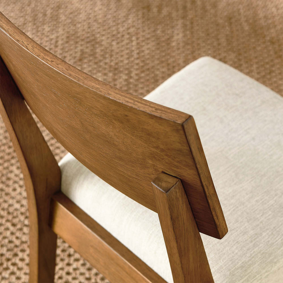 Detail of the Pax dining chair back and seat upholstery layered over a textured woven natural rug || EEI-6804-ACO-HLB || detail_room