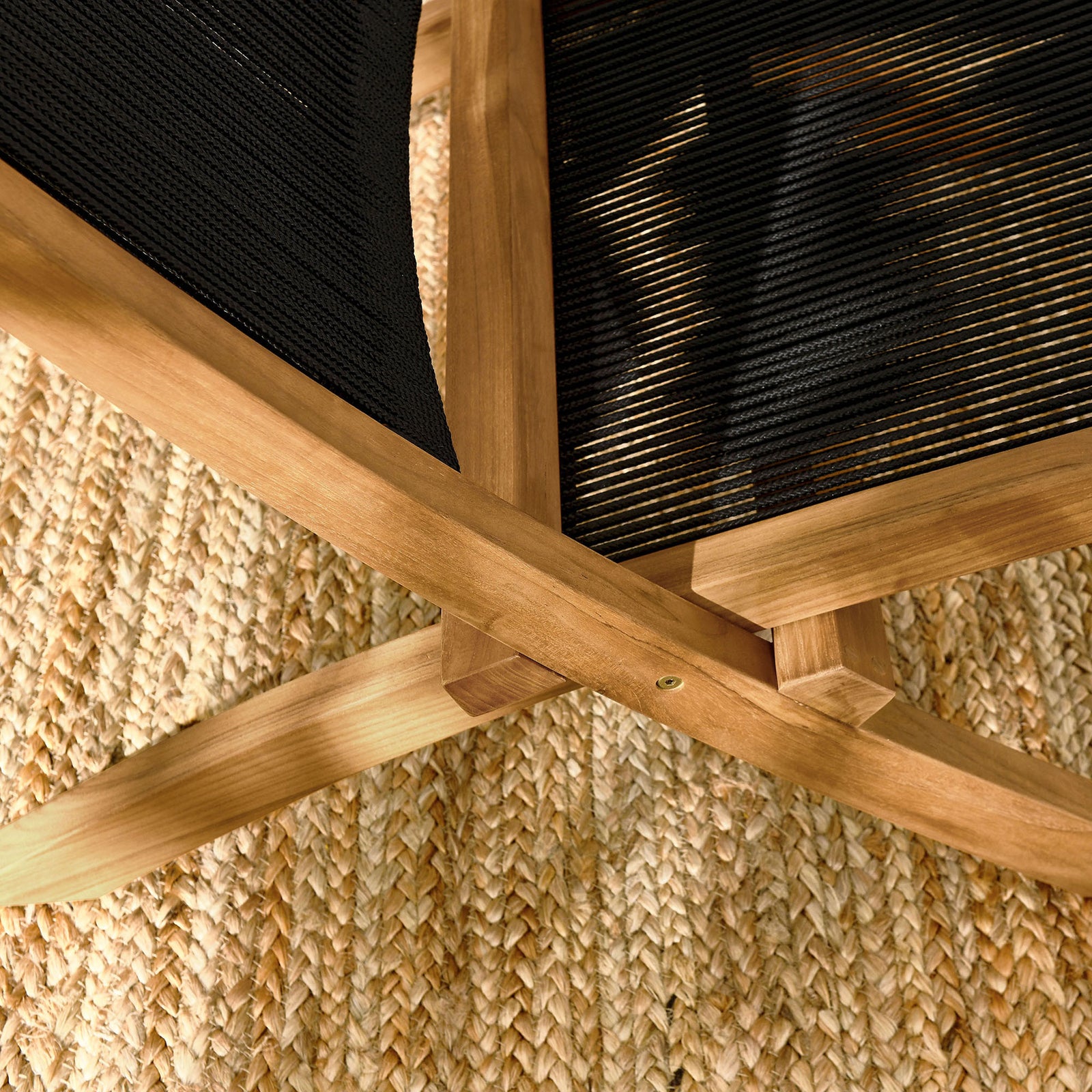 Teak frame joinery and black rope seat rest over a textured woven outdoor rug || EEI-6808-NAT-BLK || detail_room