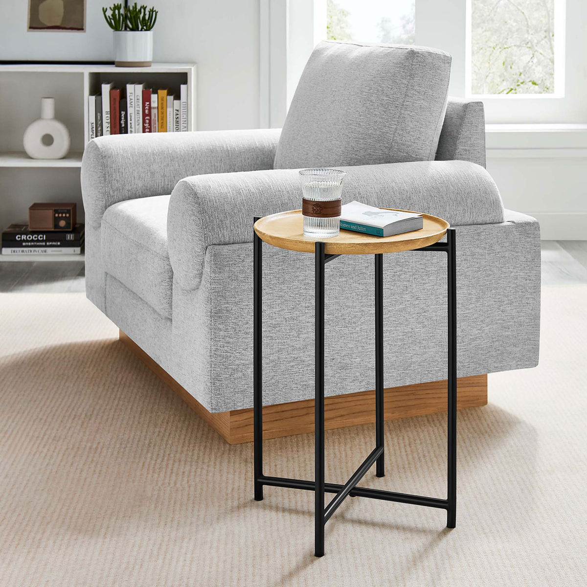 Round oak and black metal side table next to a sofa, perfect for drinks or a small plant || EEI-6832-OAK || front_angle_room