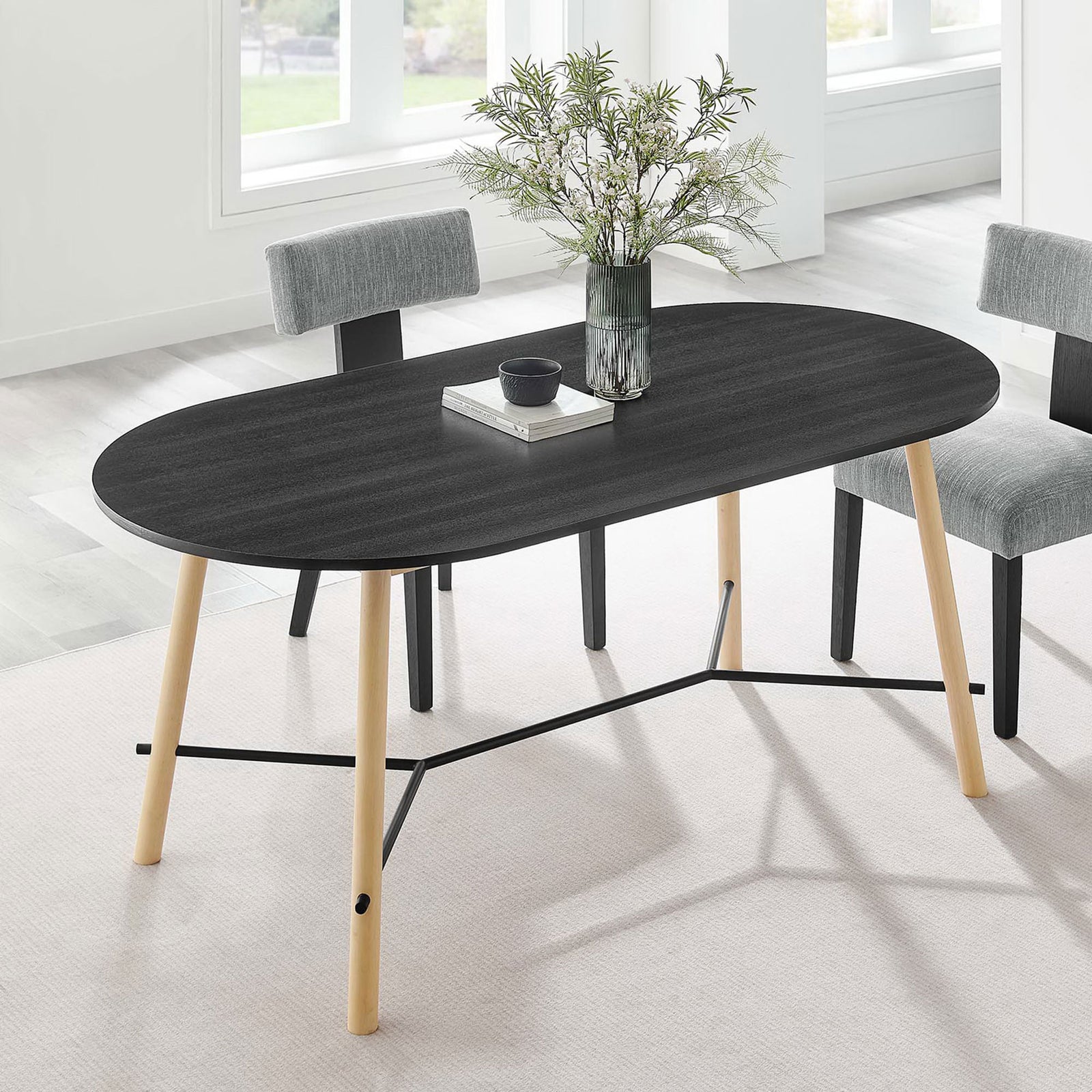 Top view of the black wood-grain dining table with books and vase styled in a light-filled room || EEI-6836-BLK-OAK || top_angle_room