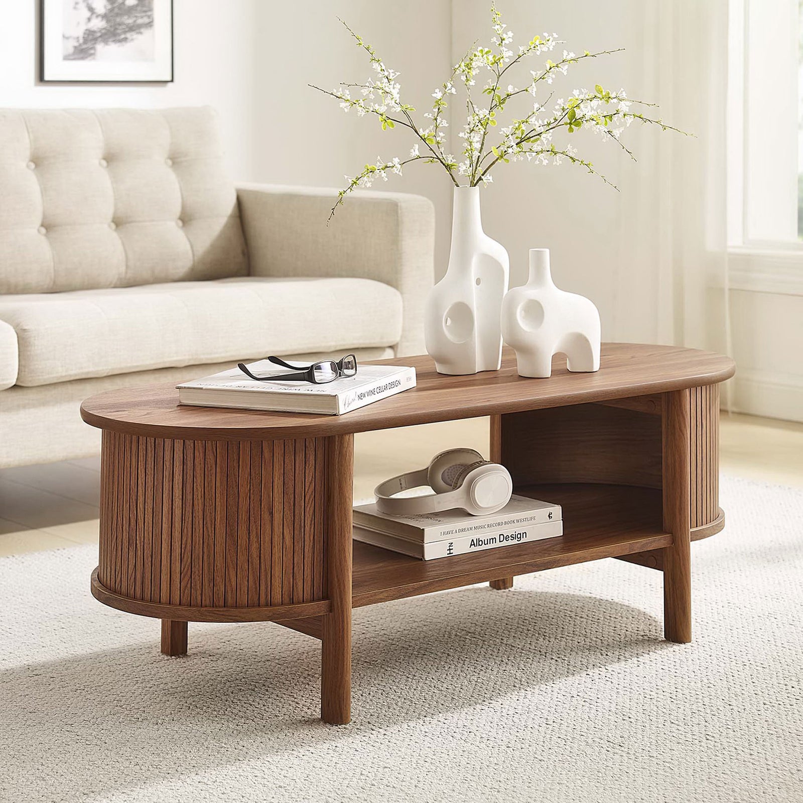 Walnut coffee table warms the room with fluted sides, curved edges, and an open shelf || EEI-6837-WAL || front_angle_room