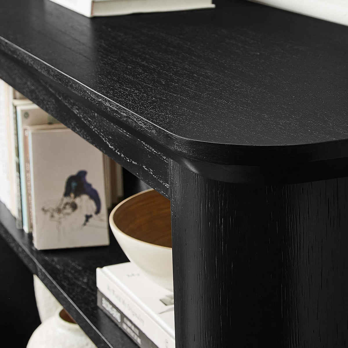 Rich black wood grain and rounded edges complement books and decor on the open shelves || EEI-6849-BLK || detail_room