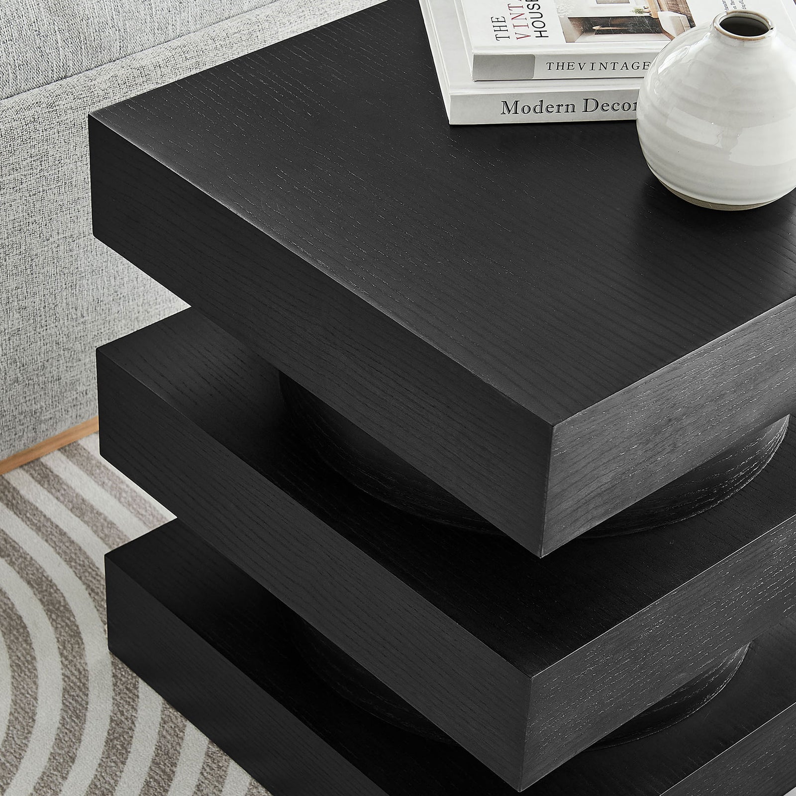 Black totem end table styled beside a sofa with books and ceramic decor on the square top. || EEI-6864-BLK || detail_room