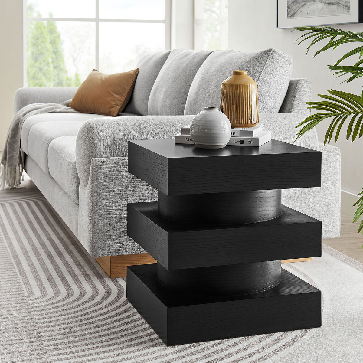 Perpetuate black totem end table accenting a modern sofa in a bright, inviting living room. || EEI-6864-BLK || front_angle_room
