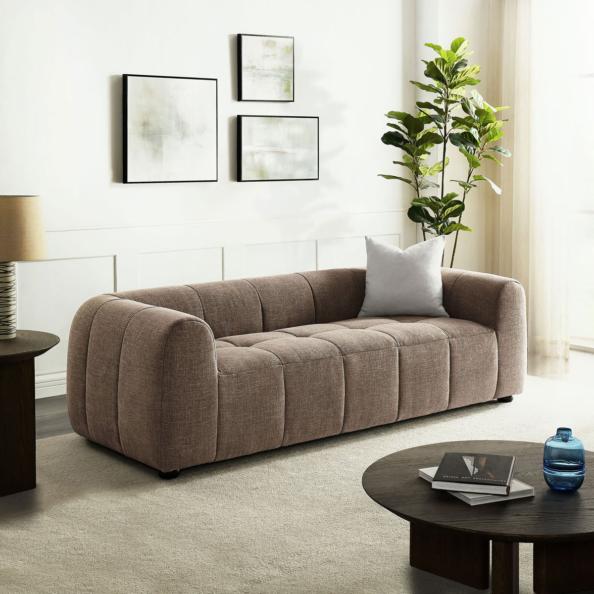 Mocha upholstered sofa centered in a modern living room with art, greenery, and warm lighting || EEI-6866-MOC || front_angle_room