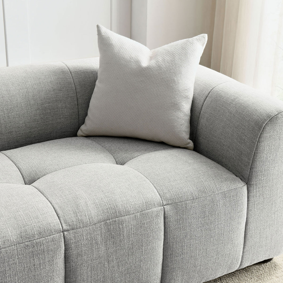 Cozy corner of the Liana sofa styled with a textured accent pillow, showcasing the soft pewter fabric in natural light || EEI-6866-PEW || detail_room