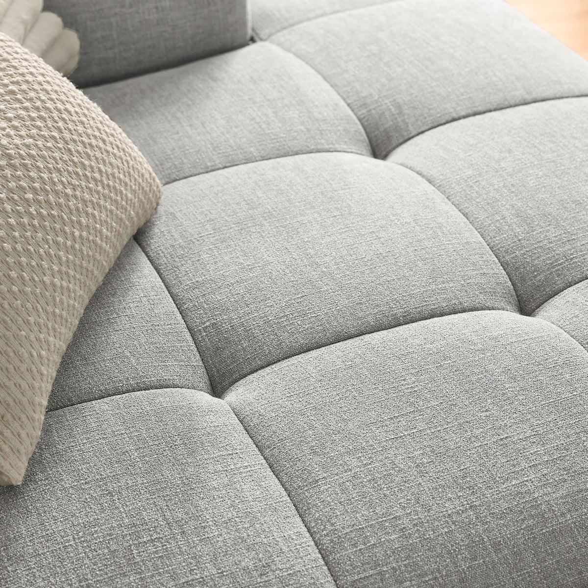 Close-up of the Liana sectional seat showing the soft woven pewter fabric and deep tufted grid. || EEI-6869-PEW || swatch_room