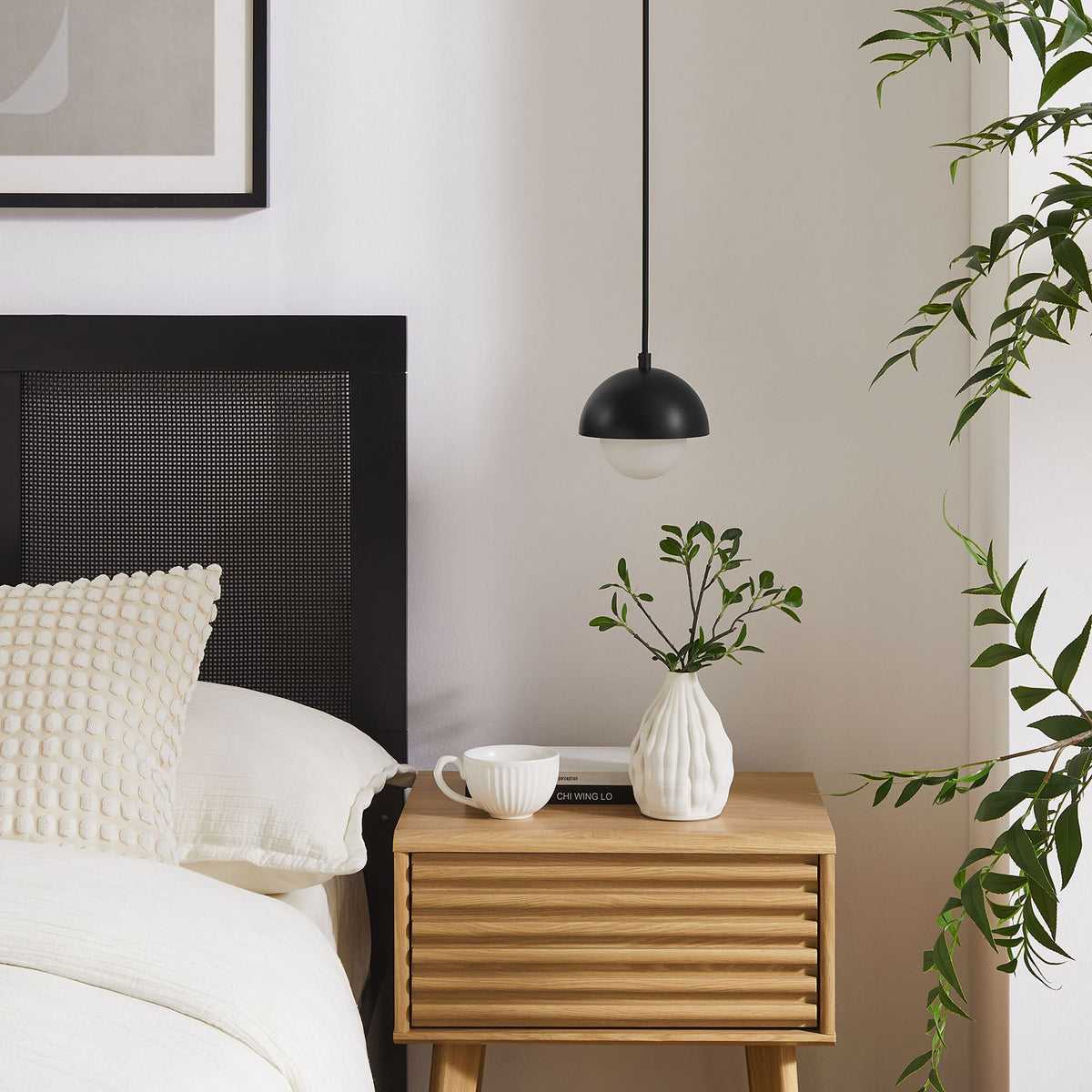 Black globe pendant bringing modern contrast above a light wood nightstand in a cozy bedroom setting || EEI-6870-BLK || front_room
