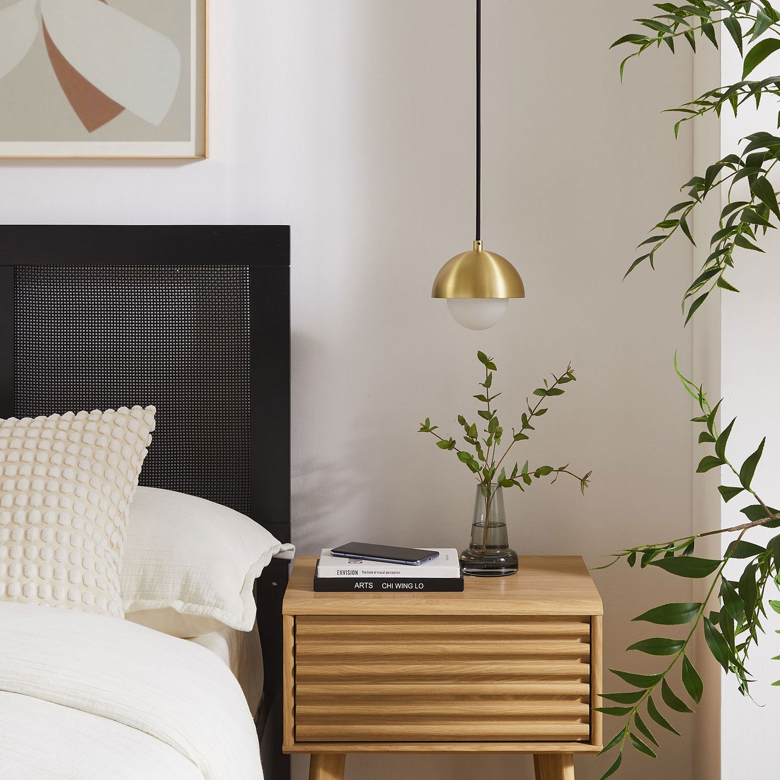 Brass globe pendant adds a warm modern accent above a wood nightstand in a cozy bedroom setting || EEI-6870-BRA || detail_room