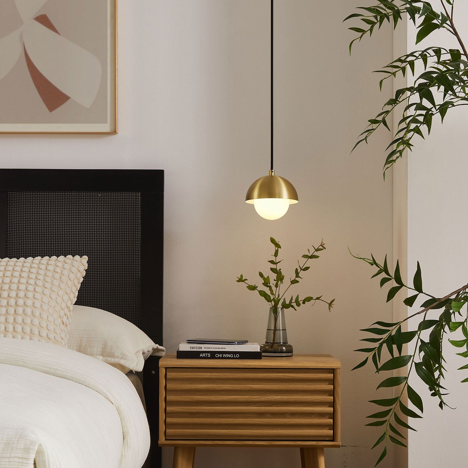Illuminated brass globe pendant casting soft light beside a modern bed and nightstand arrangement || EEI-6870-BRA || detail_on_room
