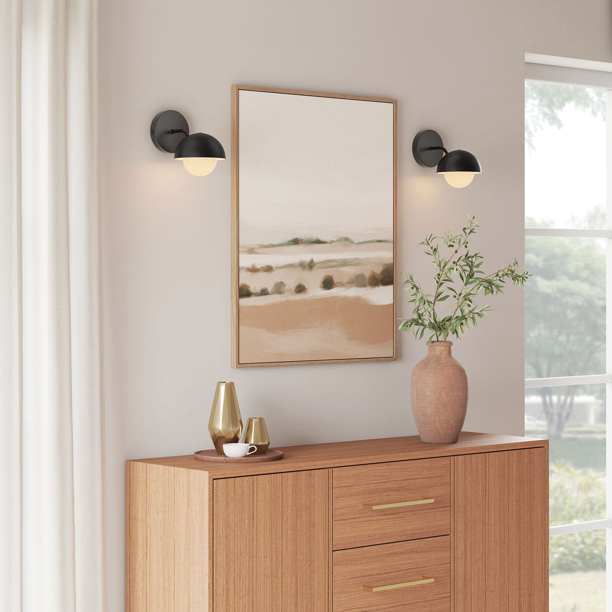 Pair of black globe sconces flank artwork to bathe the console vignette in cozy ambient light || EEI-6871-BLK || front_angle_on_room