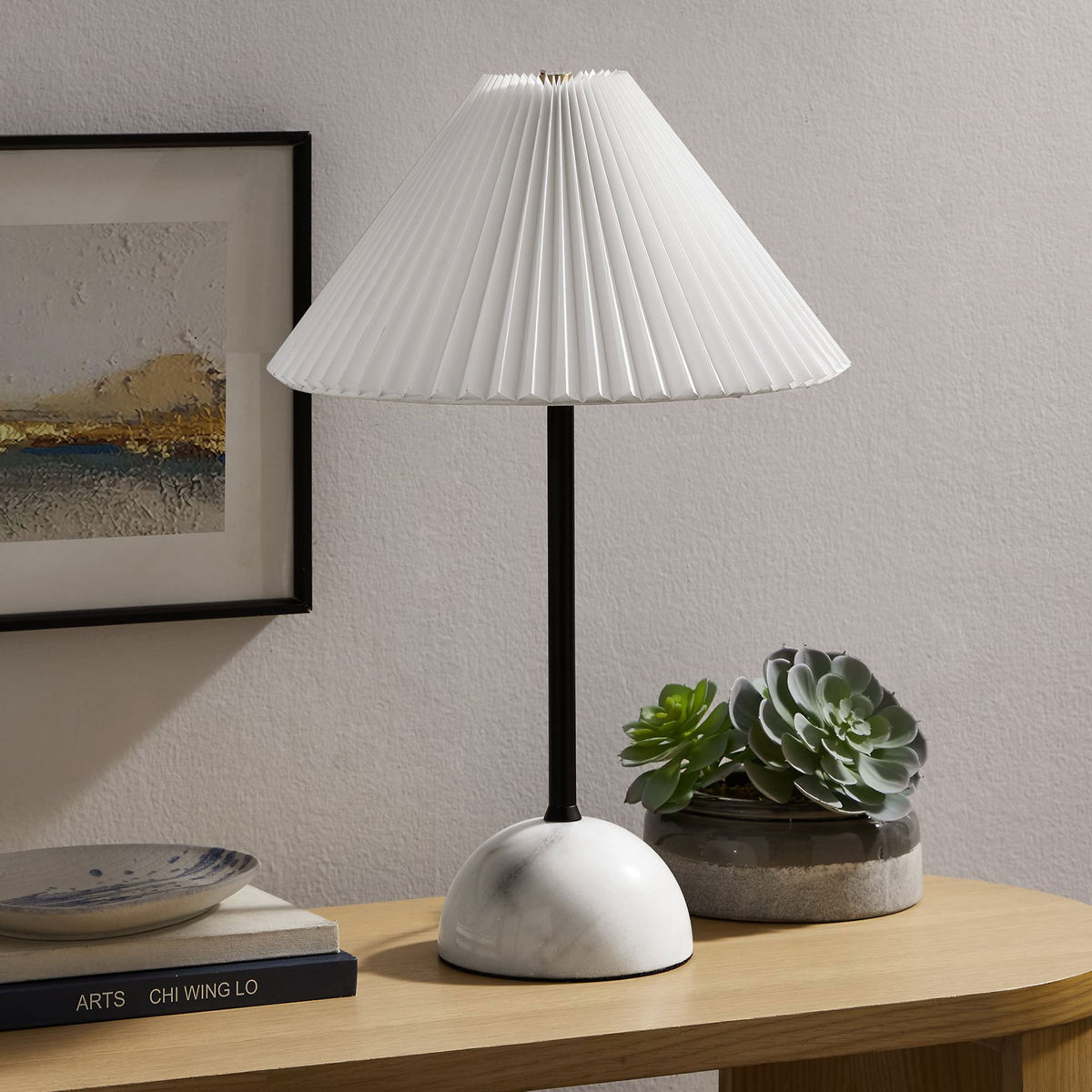 Illusion lamp accenting a console table with its slim black stem and rounded marble base. || EEI-6878-BLK || front_angle_room