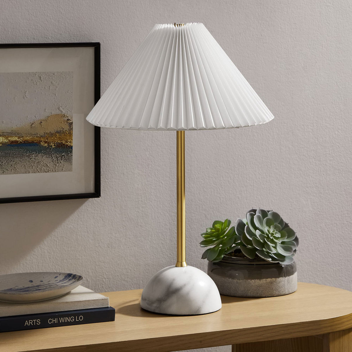 Illusion lamp styled on a console table with brass stem, marble dome base, and pleated white shade. || EEI-6878-BRA || front_angle_room