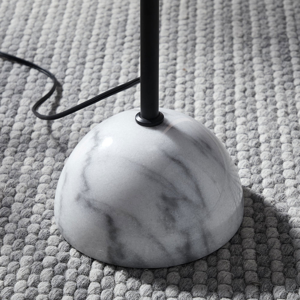 White marble dome base of the Illusion floor lamp resting on a textured gray rug for a cozy modern look || EEI-6879-BLK || leg_room