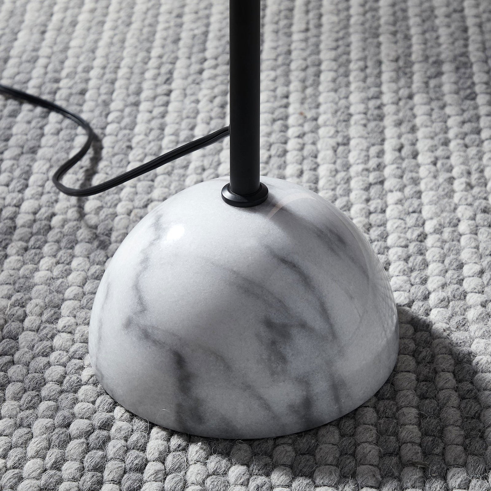 White marble dome base of the Illusion floor lamp resting on a textured gray rug for a cozy modern look || EEI-6879-BLK || leg_room