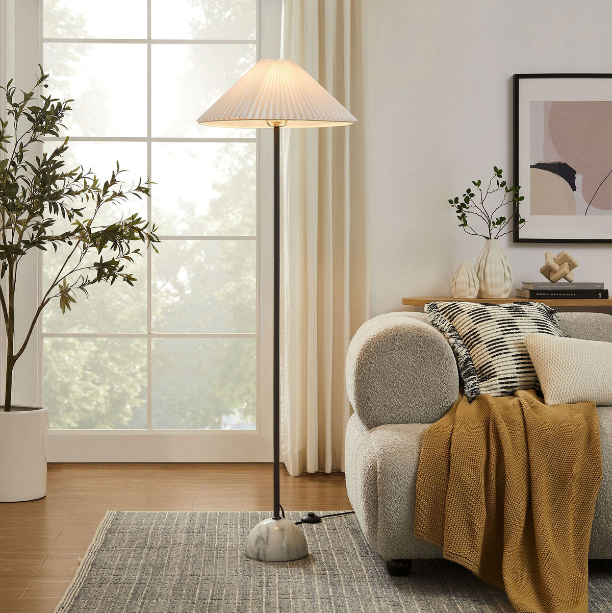 Illusion floor lamp illuminating a cozy living room beside a sofa with its pleated shade and marble dome base || EEI-6879-BLK || front_on_room
