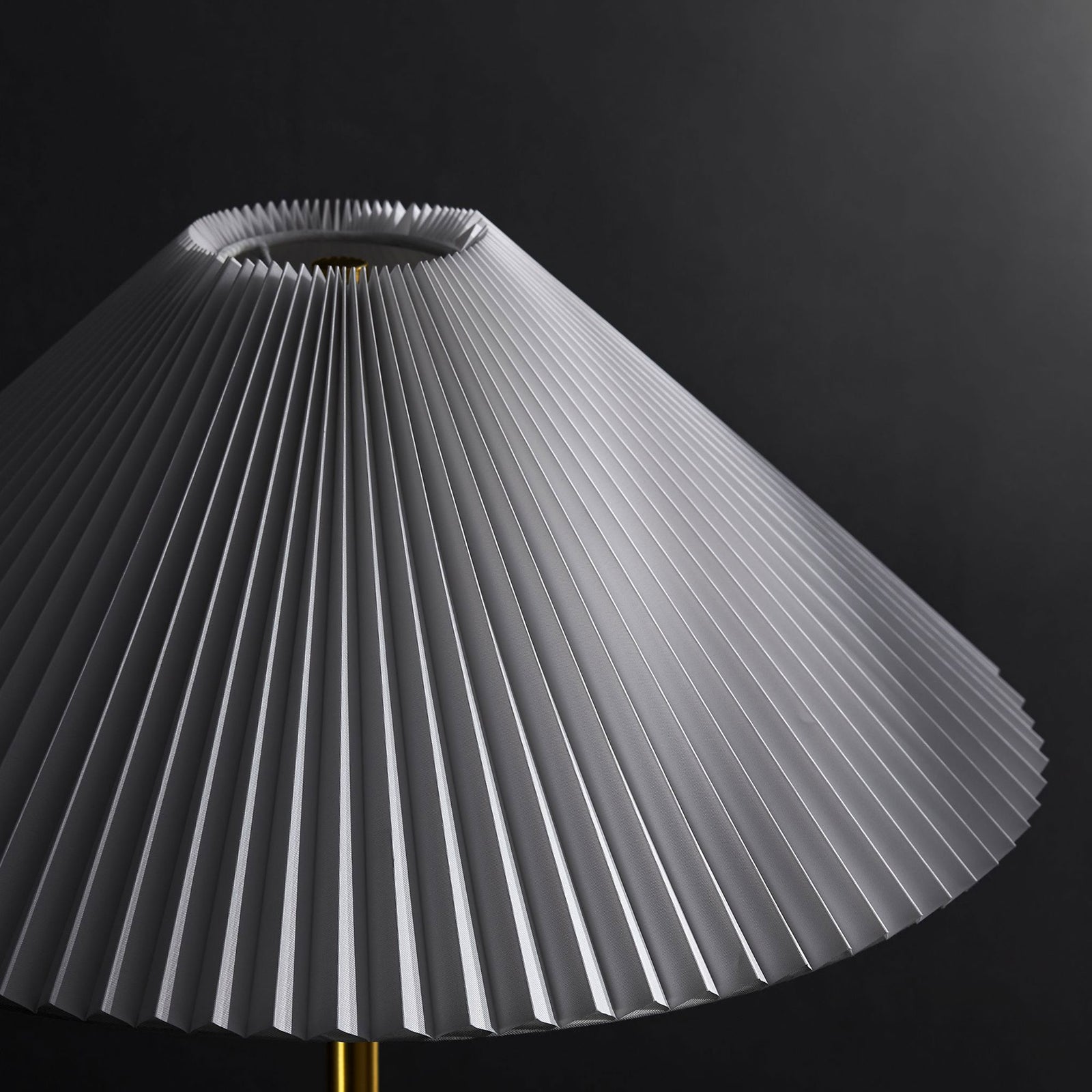 White pleated lamp shade highlighting crisp folds against a dramatic dark backdrop || EEI-6879-BRA || shade_studio