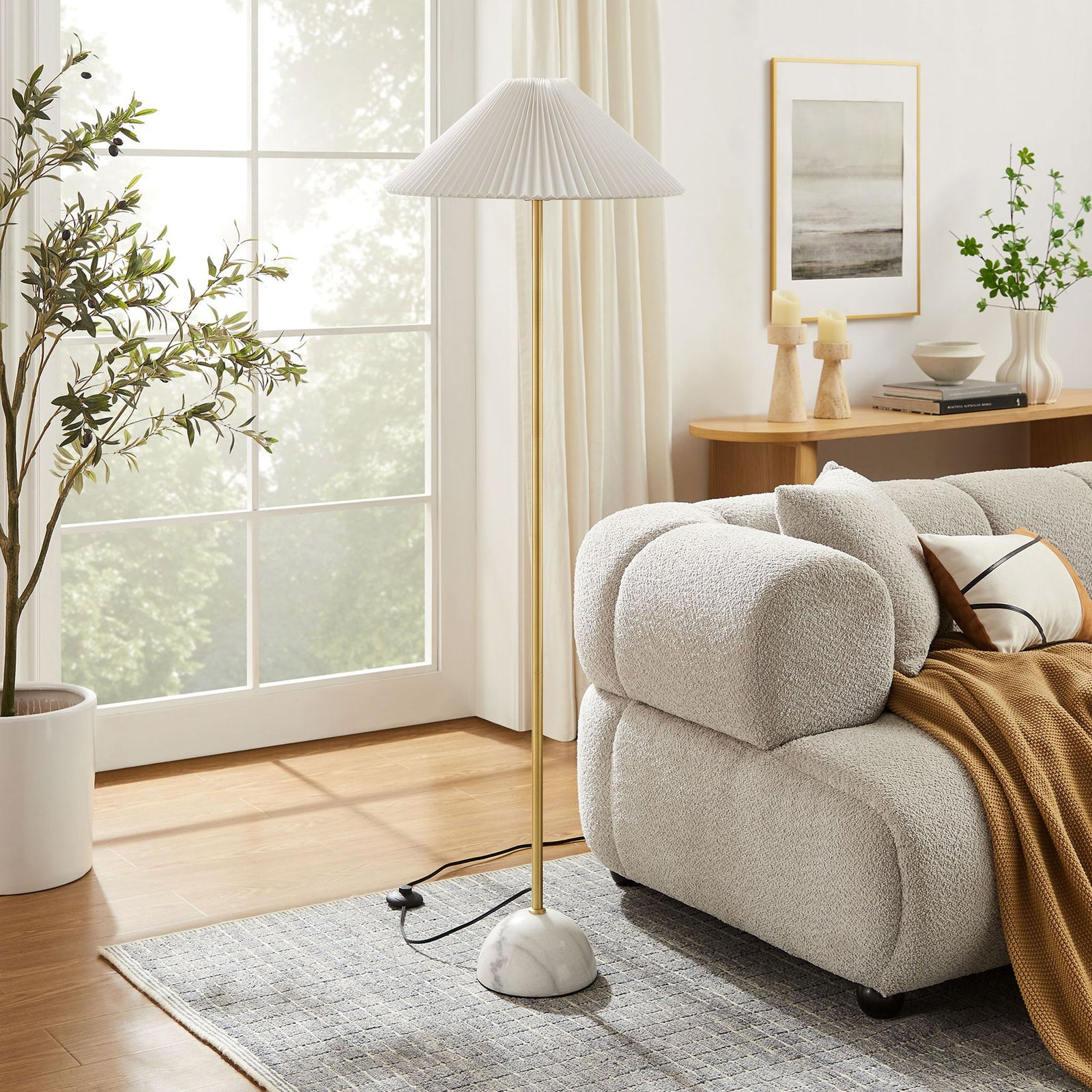 Modern brass floor lamp with marble base and pleated shade beside a cozy sofa in a bright living room || EEI-6879-BRA || front_angle_room