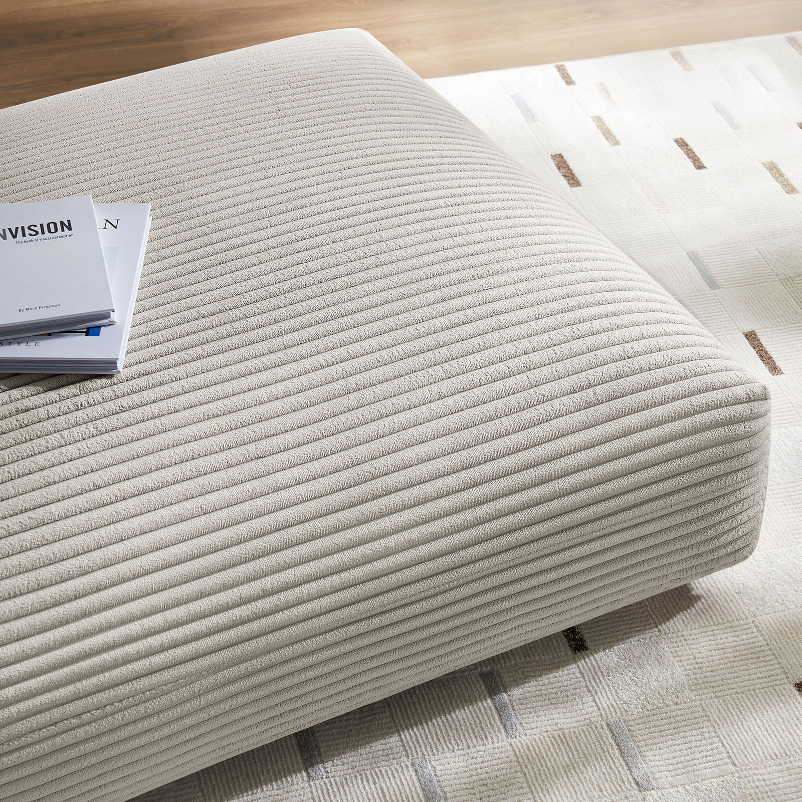 Almond corduroy ottoman styled on a patterned area rug, ideal as a low coffee table or footrest || EEI-6888-ALM || detail_room