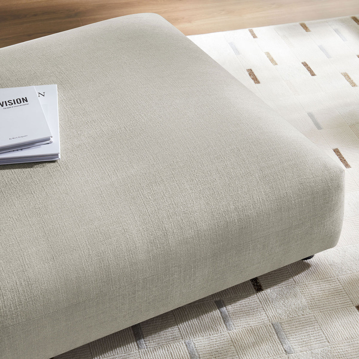 Linen ottoman blends with contemporary decor, pairing its soft woven texture with a patterned rug and wood flooring || EEI-6889-LIN || detail_room