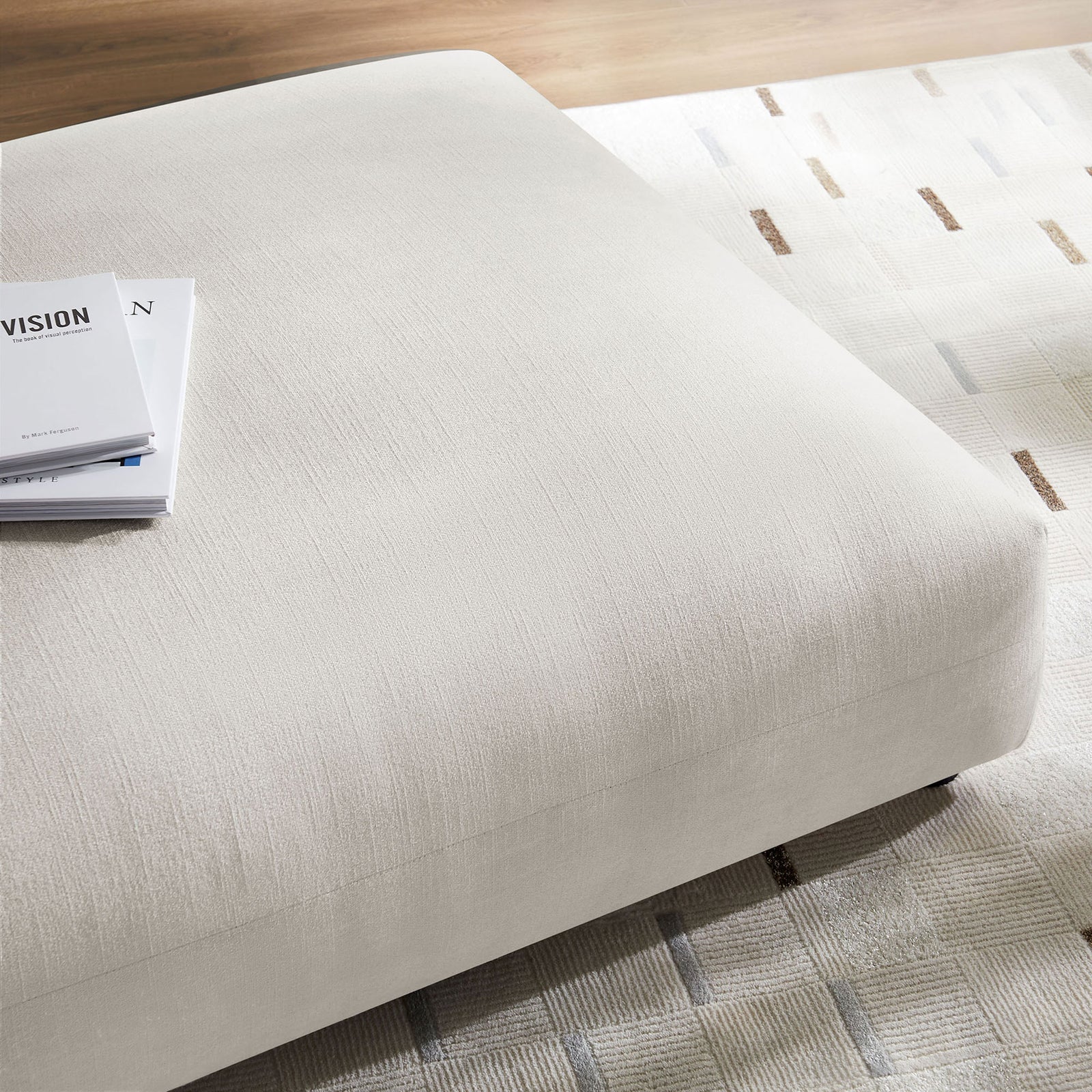 Textured salt ottoman surface styled with a book on a patterned rug in a modern living room || EEI-6889-SAL || detail_room