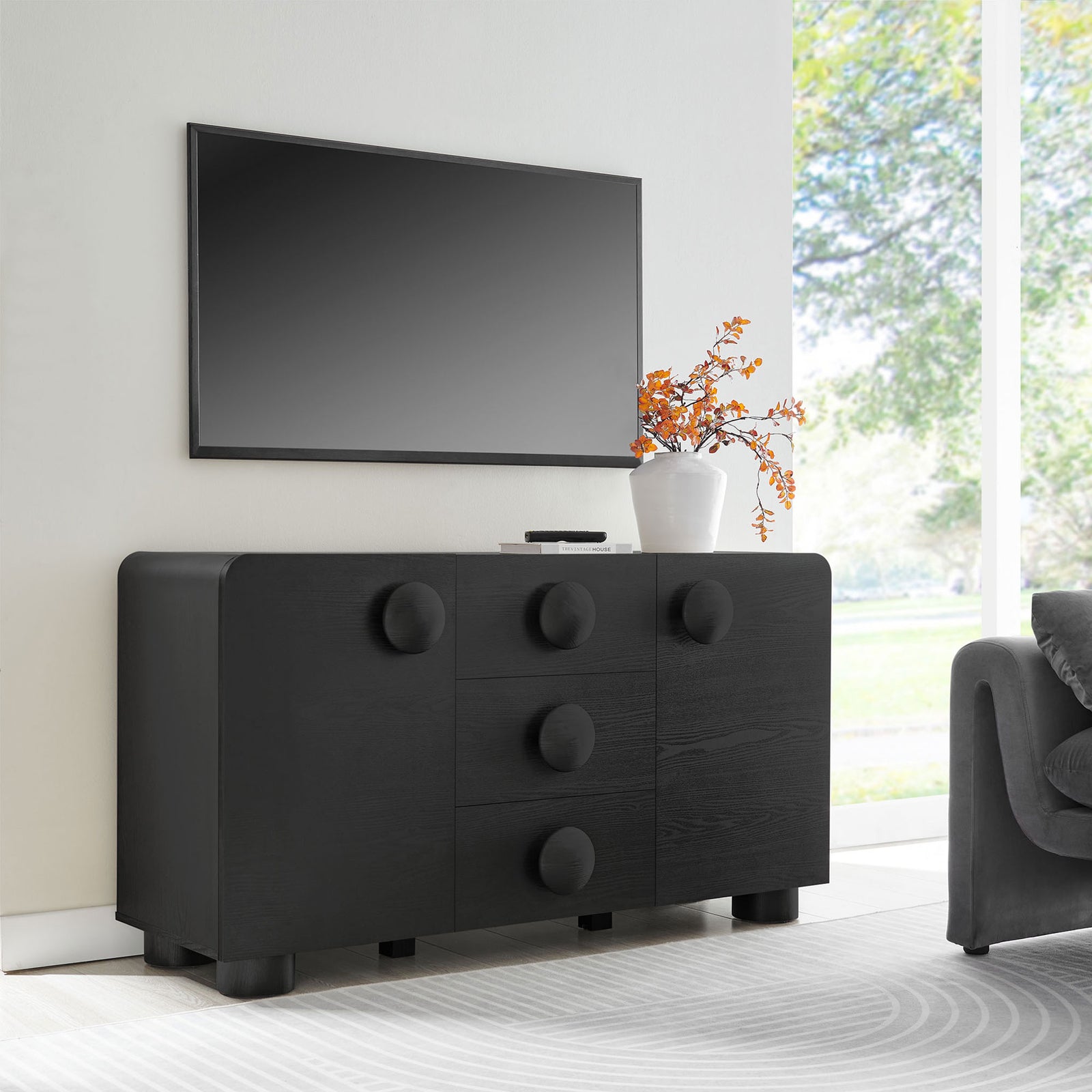 Black Sonnet sideboard used as a media console beneath a wall mounted TV in a modern living room || EEI-6892-BLK || front_angle_room