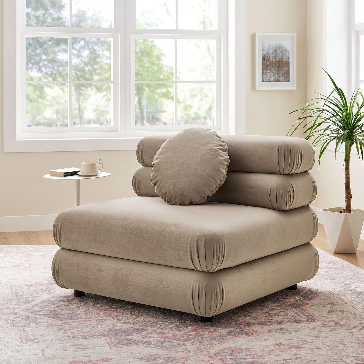 Relaxed taupe velvet chair elevates living spaces with inviting curves and a plush round pillow. || EEI-6896-TAU || front_angle_room